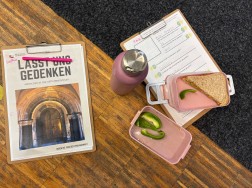 Auf dem Fotos sieht man ein Klemmbrett mit einem Stift. Auf einem zweiten Klemmbrett liegt eine ge&ouml;ffnete Fr&uuml;hst&uuml;cksdose, daneben eine Thermosflasche