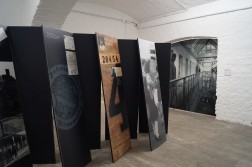 Innenansicht der Gedenkstätte Brauweiler mit Tafeln auf denen thematische Quellen, Fotos und Texte abgebildet sind