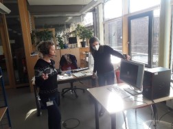 Im Lesesaal des LVR-Archivs stehen Ariane Jäger und Kerstin Nagl vor einem Bildschirm und kommunizieren per Online-Videokonferenz mit einer Schulklasse.
